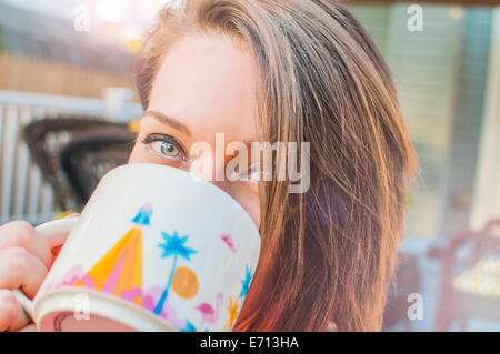 Close up of young woman drinking coffee mug de Banque D'Images