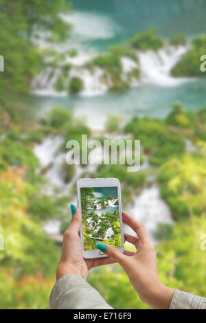 Fille de prendre des photos sur un téléphone cellulaire dans le parc national des Lacs de Plitvice en Croatie Banque D'Images