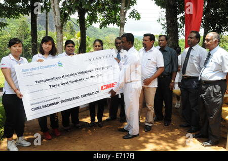 Colombo, Sri Lanka. Sep, 2014 3. Le personnel de travail main sur un chèque lors d'une cérémonie à Colombo, Sri Lanka, 3 septembre 2014. China Machinery Engineering Corporation (CMEC) a fait don de livres de bibliothèque, des ordinateurs, des filtres à eau, de lampes à énergie solaire et offert des bourses aux étudiants dans une école près de Sri Lanka's historic Fa-Hien grottes. Crédit : Yang Meiju/Xinhua/Alamy Live News Banque D'Images