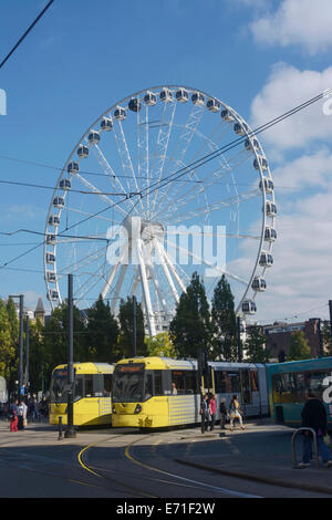 Le tramway Metrolink passant par Piccadilly, Manchester, Manchester avec l'Œil dans l'arrière-plan. Banque D'Images