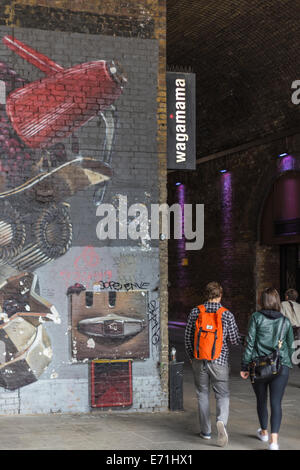 Couple en train de marcher dans le tunnel Pont Clink, Southwark, Londres, Angleterre, Royaume-Uni Banque D'Images