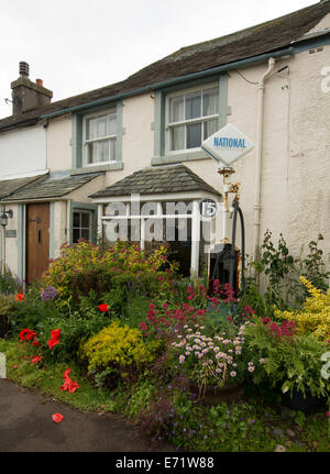 Chambre et petit jardin avec assortiment coloré de plantes à fleurs de printemps au village côtier de Holmrook, Cumbria, Angleterre Banque D'Images