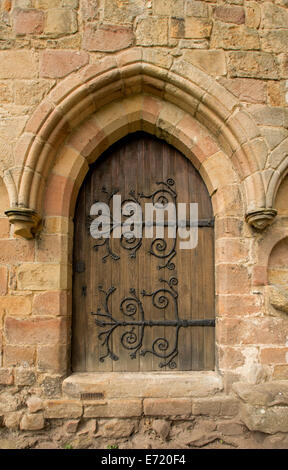 Porte en bois voûté avec d'énormes et spectaculaires charnières décoratives dans mur de pierre en ruines de Bolton Angleterre prieuré historique Banque D'Images