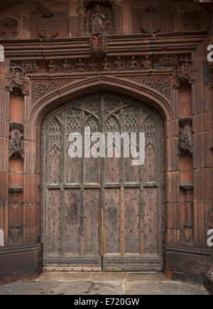 Porte en bois cintrées spectaculaires avec la sculpture complexe entouré de pierres rouge finement sculptés à l'entrée du quartier historique de la cathédrale de Chester en Angleterre Banque D'Images