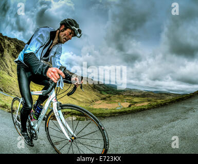 Une course cycliste grimpant Hardknott Pass dans le Lake District. Banque D'Images