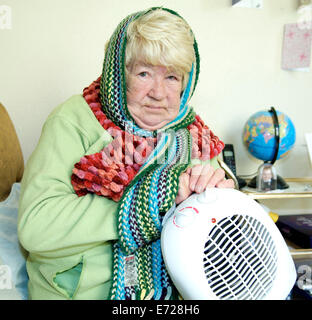 Vieille dame essayant de garder au chaud en hiver froid Banque D'Images