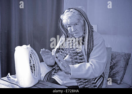 Vieille dame essayant de garder au chaud en hiver froid Banque D'Images