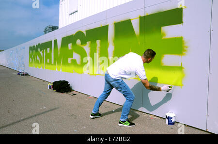 Graffiti artistes qui préfèrent rester anonymes commencent à travailler la pulvérisation des panneaux publicitaires autour de la construction de la tour i360 Brighton UK Banque D'Images