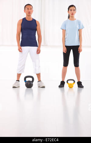 L'homme et de la femme asiatique faisant électrique exercice crossfit bell Banque D'Images