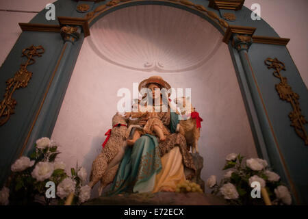 Une sculpture de la Vierge Marie vue comme la Divine Bergère, tenant un bébé Jésus jouant avec agneaux décore une église Banque D'Images