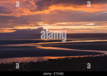 La vue depuis la promenade de Prestwick à mesure que le soleil se couche derrière l'île d'Arran en Écosse. Banque D'Images