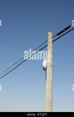 Ligne d'alimentation en bois pôle et ciel bleu clair. Banque D'Images