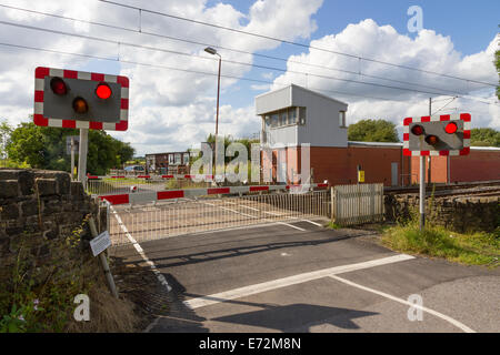 Tram Train Hagside avec passage à niveau signal fort désaffecté, les signaux et les barrières abaissées à Manchester Banque D'Images