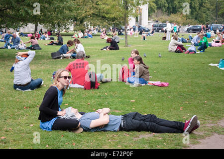 Les gens se détendre sur l'herbe à l'extérieur de Buckingham Palace, London, UK Banque D'Images