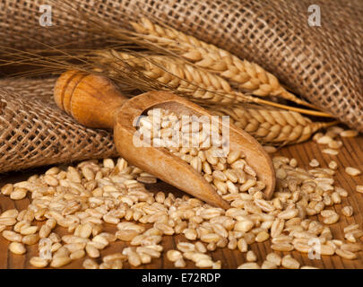 Scène rurale avec des grains et des épis de blé sur fond de bois. Banque D'Images
