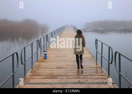 Lonely Woman walking le pont flottant des piétons d'Agios Achilleios islet, Mikri Prespa Lake, Florina, Macédoine, Grèce Banque D'Images