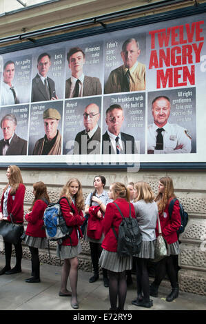 Ecolières sous une affiche de théâtre "Douze hommes en colère" au théâtre Garrick, Charing Cross Road, London Banque D'Images