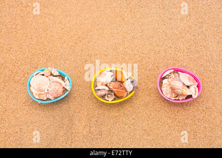 Décorations de Pâques paniers d'oeufs sur la plage remplie de coquillages pour l'utiliser comme arrière-plan. Prix pour copier le long de la moitié supérieure gauche Banque D'Images