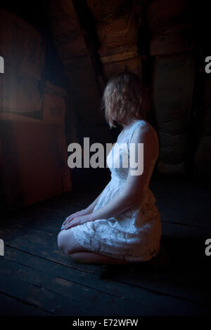 View of young woman kneeling on floor Banque D'Images