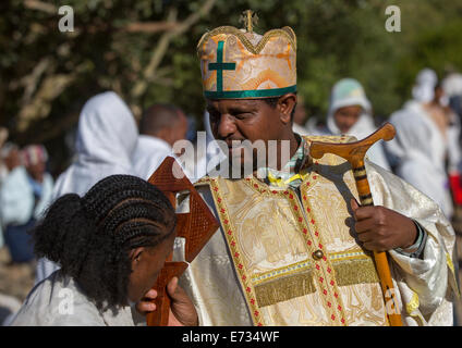 Prêtre orthodoxe éthiopienne la bénédiction d'une croix des pèlerins lors de l'Épiphanie Timkat Festival, Lalibela, Éthiopie Banque D'Images