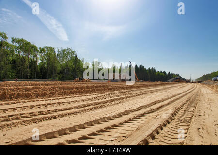 Les bulldozers des traces sur le sable pendant la construction de la route Banque D'Images
