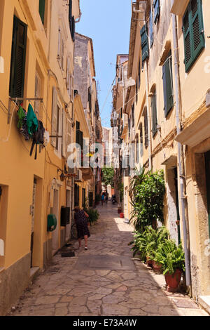 Ruelle avec dame balayant, Vieille Ville, la ville de Corfou, l'UNESCO Site, Corfou, îles Ioniennes, îles grecques, Grèce Banque D'Images