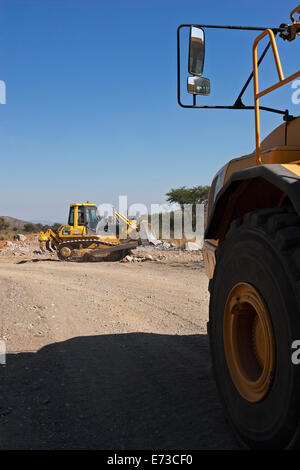 Du côté du tombereau de transport à la pelle hydraulique travaillant sur la construction de la route d'accès à la nouvelle mine de platine. Le tombereau à benne basculante attend pour renverser la charge rocheuse. Afrique du Sud Banque D'Images