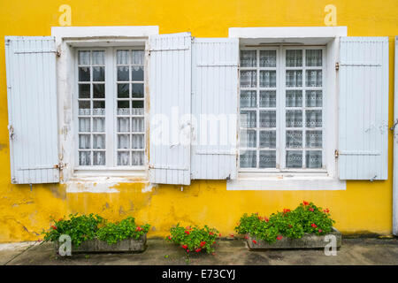 Chambre avec mur jaune vif et blanc fenêtres avec volets, Monpazier, Dordogne, Aquitaine, France Banque D'Images