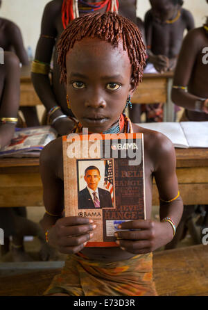 Tribu Hamer Girl Holding A Book Avec Barack Obama sur la couverture dans une école, Turmi, vallée de l'Omo, Ethiopie Banque D'Images