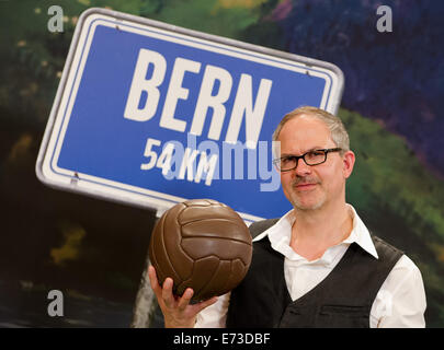 Et le directeur de théâtre musical Gil Mehmert pose avec un ballon de football dans sa main sur scène lors d'une répétition de la comédie musicale "Le Miracle de Berne" à Hambourg, Allemagne, 28 août 2014. Le musical est prévu pour frapper la scène à Hambourg en novembre 2014. Photo : Daniel Bockwoldt/dpa Banque D'Images