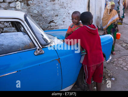 Les enfants en face d'une vieille Peugeot 404, Harar, en Ethiopie Banque D'Images