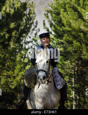 Un villageois monte un cheval blanc à travers la forêt dans le sud-ouest de la Serbie Banque D'Images