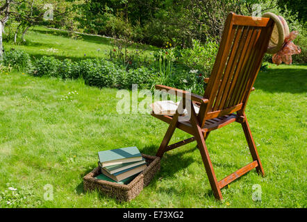 Vous pourrez vous détendre en bois, président de livres à panier et hat en cour jardin en été 24. Banque D'Images