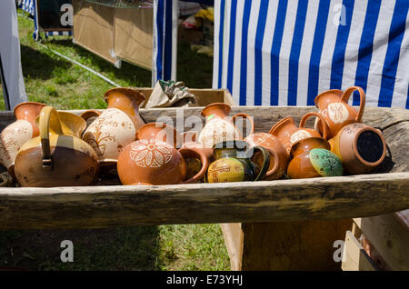 Les cruches d'argile peint couché dans l'auge en bois au marché de village Banque D'Images