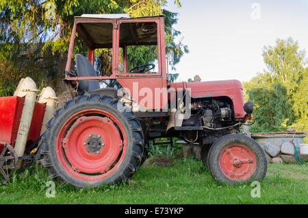 Close up de vieux rural tracteur avec roues rouges dans jardin nature Banque D'Images