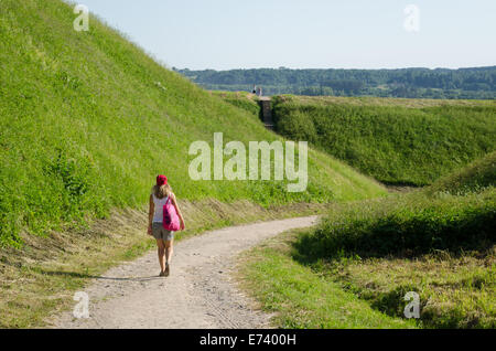 Femme touristiques à pied entre mound hills en lituanien capitale historique Kernave, UNESCO World Heritage Site. Banque D'Images