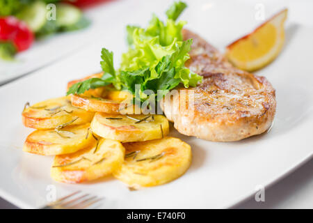 Côtelette de porc rôti avec des pommes de terre sur lave Banque D'Images