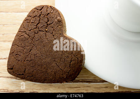Les cookies au chocolat coeur sur la soucoupe de café. Banque D'Images