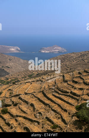 Vue de la côte nord de l'île de Tinos et à l'îlot rocheux 'Planet' dans l'arrière-plan, les Cyclades, Grèce Banque D'Images