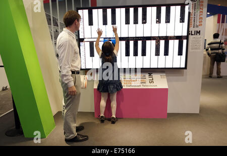 Berlin, Allemagne. 07Th Nov, 2014. Une fille joue du piano sur un 85-pouces à écran tactile sur le troisième jour de la foire commerciale de l'électronique IFA de Berlin, Allemagne, 07 septembre 2014. Cdi a lieu du 5 septembre au 10 septembre à Berlin. PHOTO : JOERG CARSTENSEN/DPA/Alamy Live News Banque D'Images