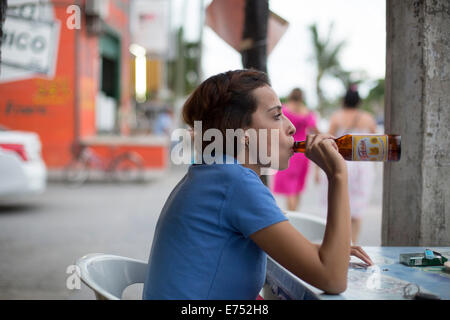 Femme buvant bière bouteille de bar à l'extérieur du cou Banque D'Images