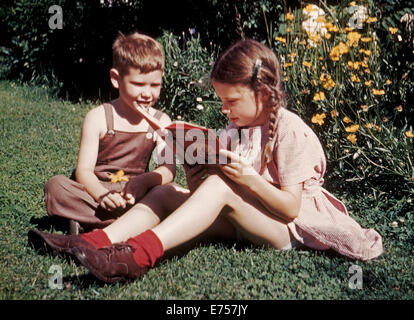 En 1945, un jeune frère et soeur ont été photographiés au début de film couleur Kodachrome en lisant un livre sur une journée d'été dans l'arrière-cour de leur maison. Comme l'un des tout premiers films de transparence (Diapositive), 35mm Kodachrome Kodak avait un film très lente vitesse de seulement ASA/ISO 10. A été introduit en 1935 Kodachrome et est passé par une variété de film plus rapide des vitesses (jusqu'à 200 ASA/ISO) et d'autres améliorations techniques jusqu'à la Eastman Kodak Company fabrication le film populaire en 2009. 1945 Historique photo. Banque D'Images