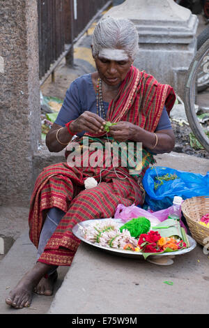 Femme de marché la production de décorations florales, Madurai, Tamil Nadu, Inde Banque D'Images