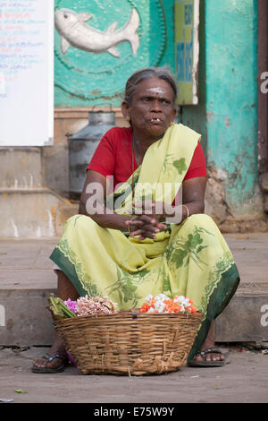 Femme assise devant un temple vente de décorations florales, Madurai, Tamil Nadu, Inde Banque D'Images