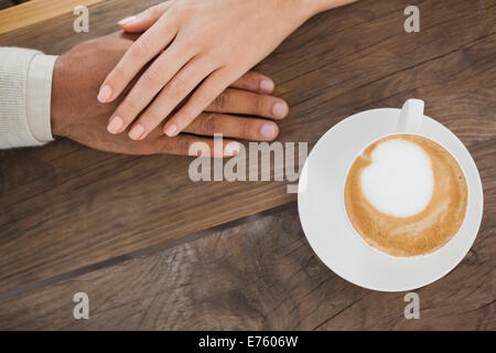 Couple holding hands à côté de cappuccino Banque D'Images