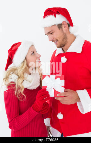 Attractive young couple wearing santa hats with gift Banque D'Images