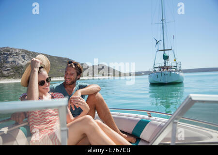 Couple assis dans un bateau sur l'eau Banque D'Images