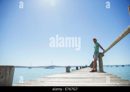 Homme debout sur un quai en bois Banque D'Images