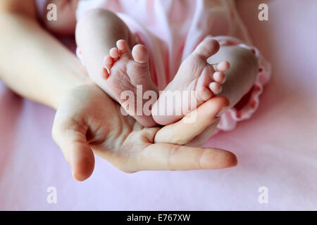 Tenir la main Parent jambes bébé fille Banque D'Images