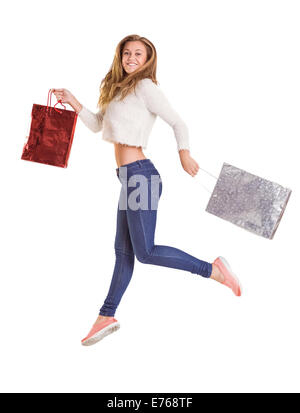 Jolie blonde jumping and holding bags Banque D'Images